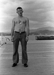 Dixon without a shirt showing his dog tags